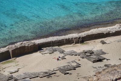 High angle view of people on rocks at beach