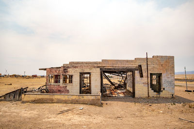 Abandoned building on field against sky