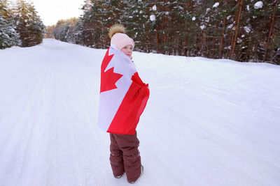 The girl is wrapped in the flag of canada