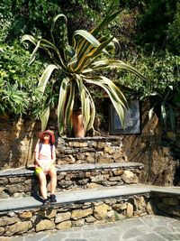 Full length of woman standing against plants