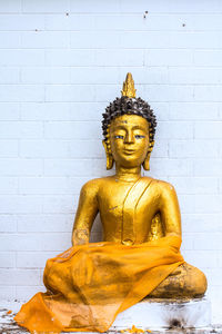 Statue against yellow wall