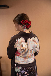 Rear view of woman standing against pink wall