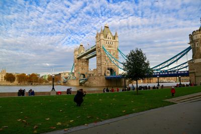 People at town square against cloudy sky