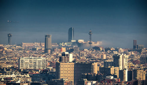 Aerial view of buildings in city against sky