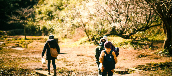 Rear view of people walking on field
