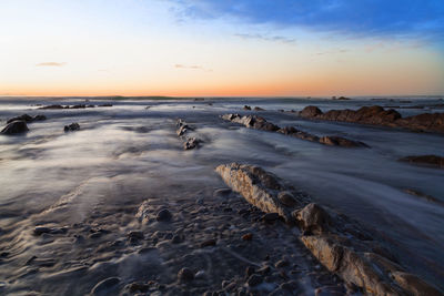 Blurred motion of sea over rocks during sunset