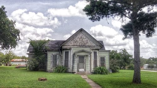 Built structure on lawn with trees in background