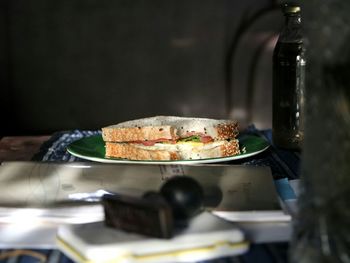 High angle view of sandwich in plate by book on table