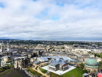 High angle view of city buildings against cloudy sky