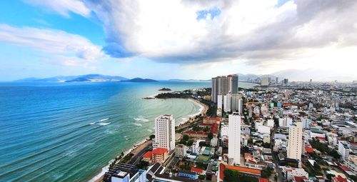 High angle view of city by sea against sky