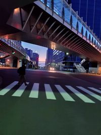 People on illuminated street amidst buildings in city at night