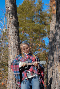 Portrait of young woman standing in forest