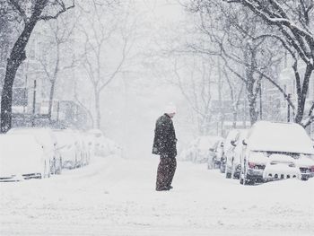 Rear view of man walking on snow covered road