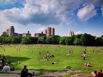 People at park against sky in city