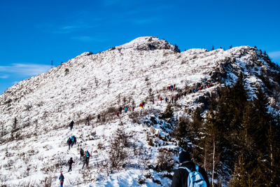 Low angle view of people on mountain against sky