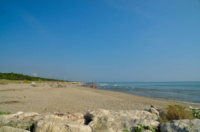 Scenic view of beach against clear blue sky