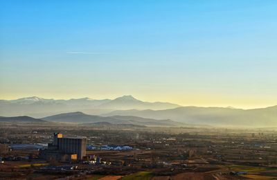 High angle view of illuminated cityscape against sky at sunset