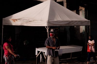 Rear view of people standing against built structure