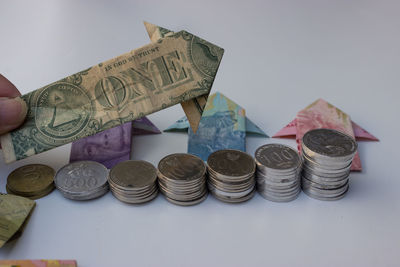 Close-up of hand holding coins on white background