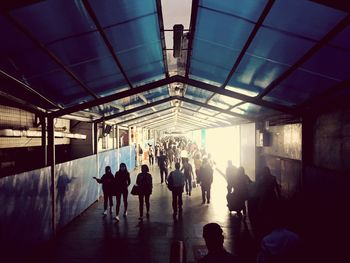 People in illuminated corridor