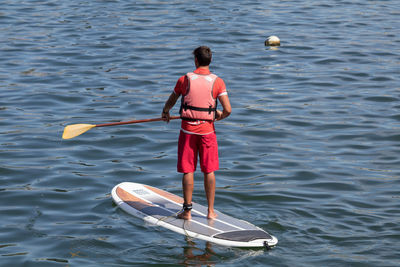 Rear view of man standing in sea