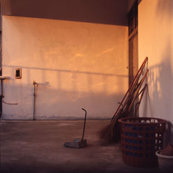 Brooms and basket in empty room