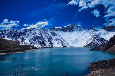 Scenic view of snowcapped mountains against blue sky