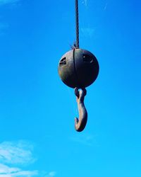 Low angle view of rope hanging against blue sky