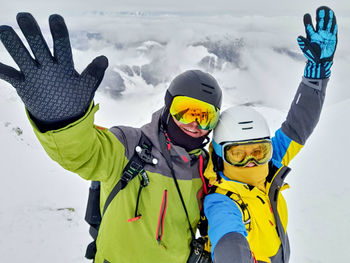 Rear view of people skiing on snow covered landscape