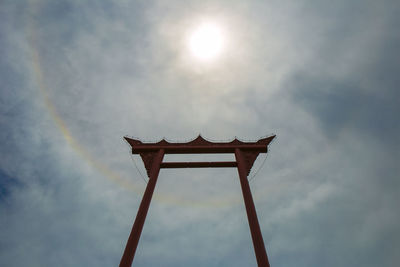 Low angle view of cross on sunny day against sky