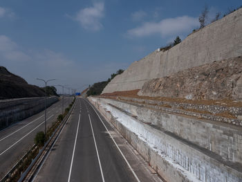 Road leading towards highway against sky