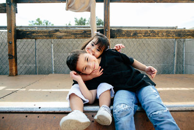 Sister and brother hug on top of skate ramp