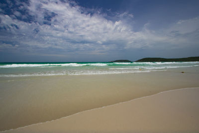 View of beach against cloudy sky