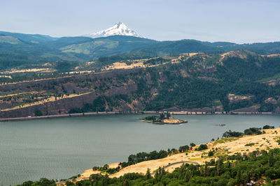 Scenic view of lake by mountains against sky