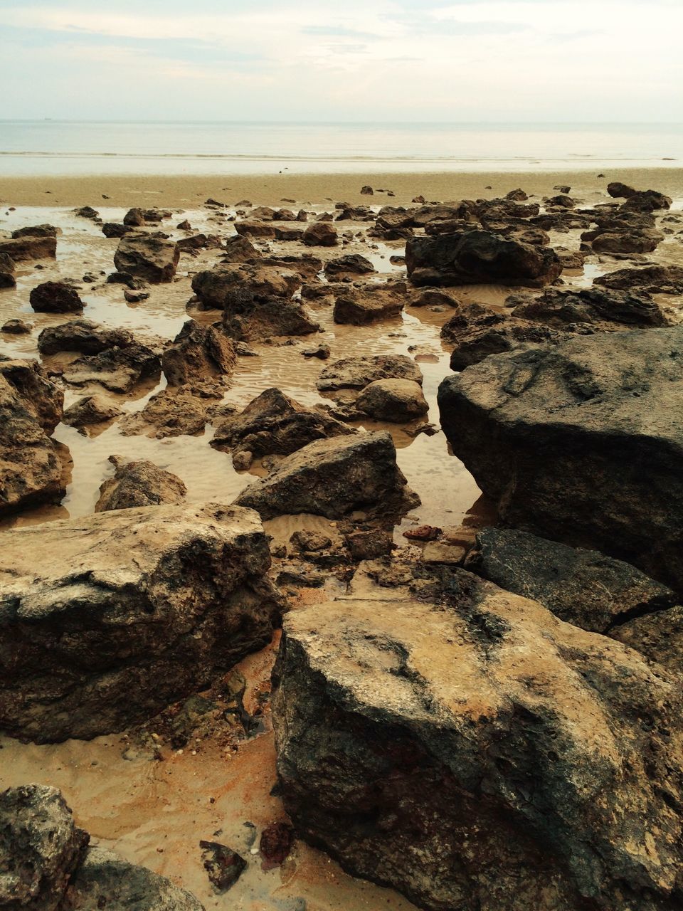 sea, horizon over water, water, beach, shore, tranquility, tranquil scene, scenics, rock - object, rock formation, beauty in nature, nature, sky, rock, coastline, sand, high angle view, cliff, idyllic, outdoors