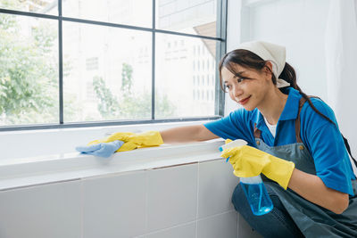 Side view of man washing hands in bathroom