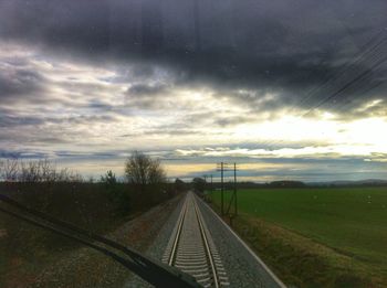 Railroad track against cloudy sky