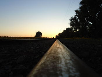 Railroad tracks amidst trees against clear sky