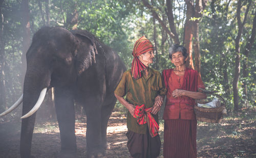 Women standing by trees in forest