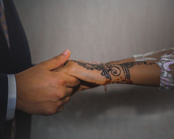 Cropped hand of bridegroom holding hands