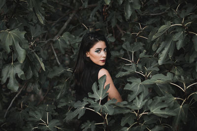 Portrait of woman standing by plants