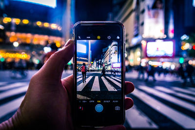 Close-up of person using mobile phone in city