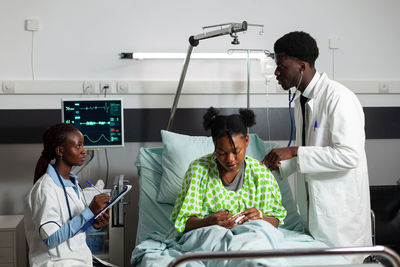 Doctors examining patient in hospital