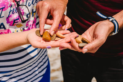 Midsection of couple holding stones