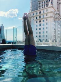 Man in swimming pool against sky in city