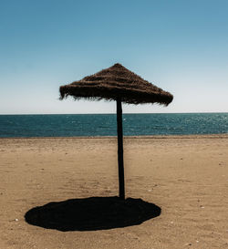 Lifeguard hut on beach against clear sky