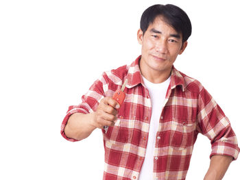 Portrait of young man standing against white background