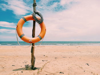 Close-up of rope tied on beach against sky