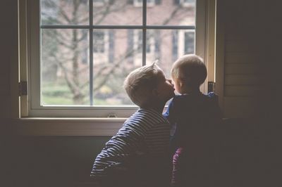 Boy looking through window