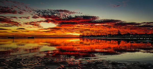 Scenic view of lake against sky at sunset